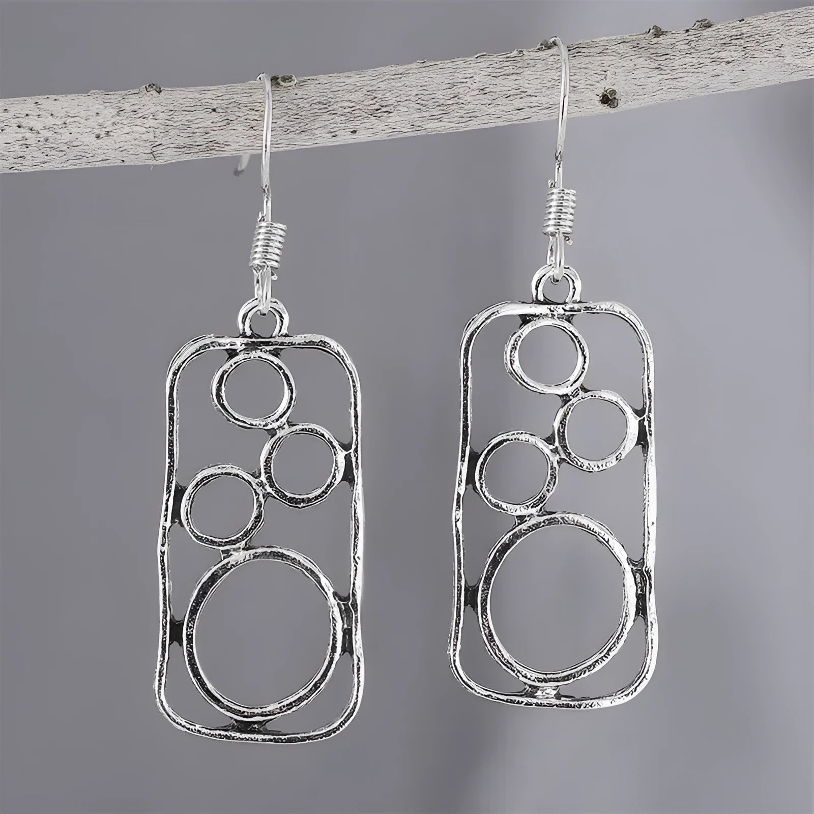 A pair of geometric round earrings with an irregular square shape in antique silver finish.