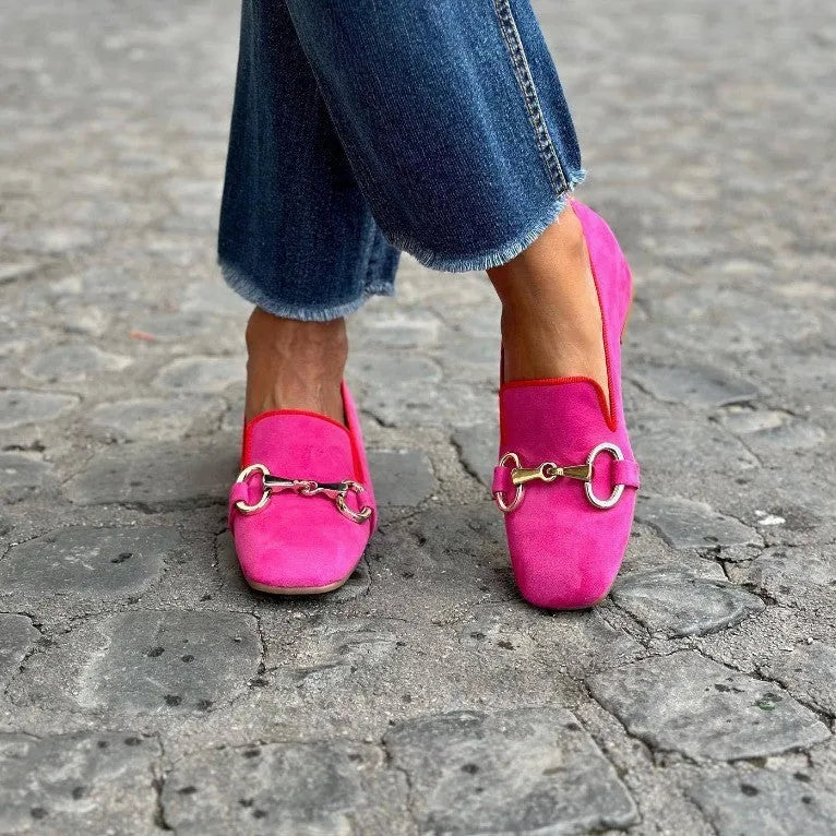 Green suede flat loafers with a round toe and metal fastener on the upper.