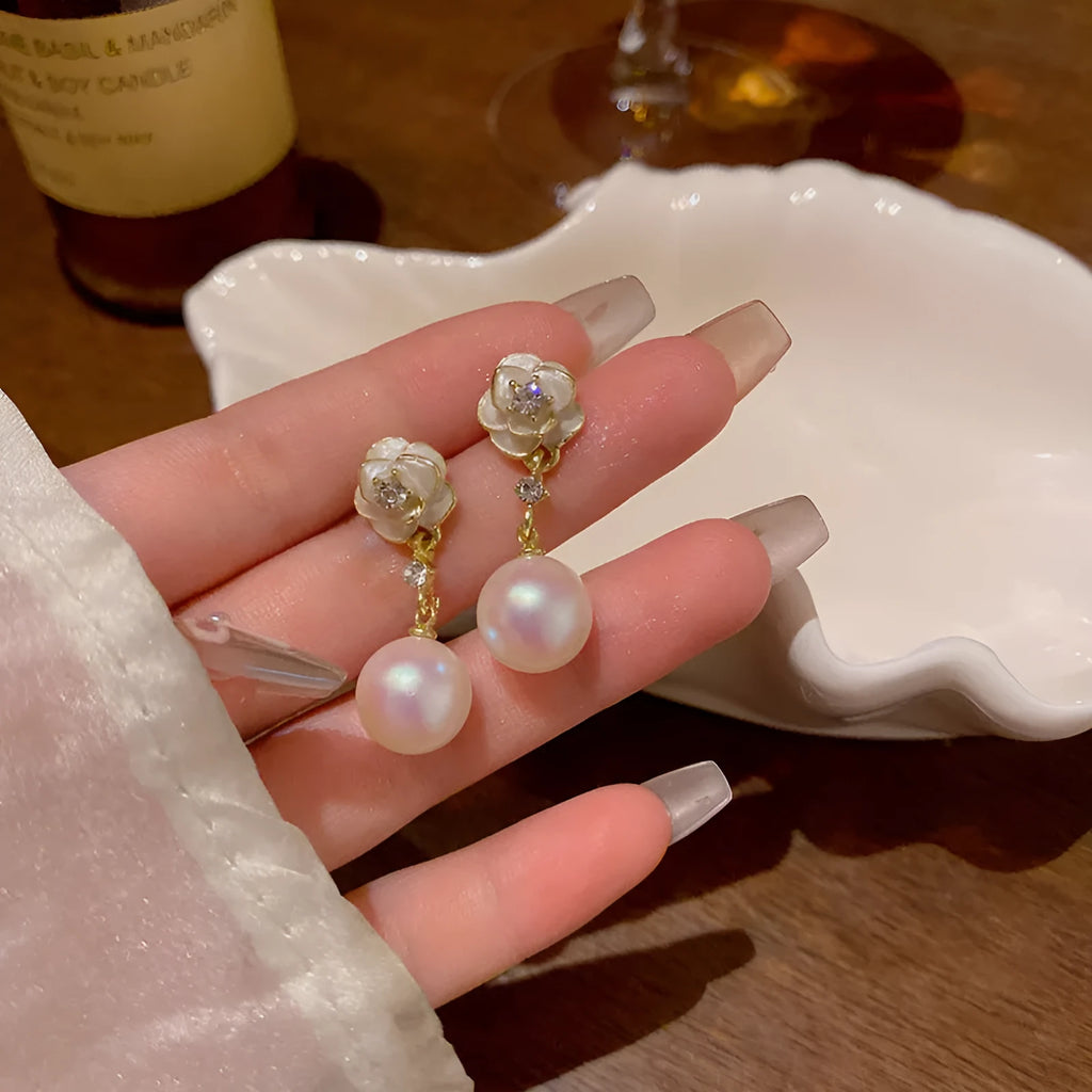 Close-up of a pair of camellia flower stud earrings for women in alloy metal.