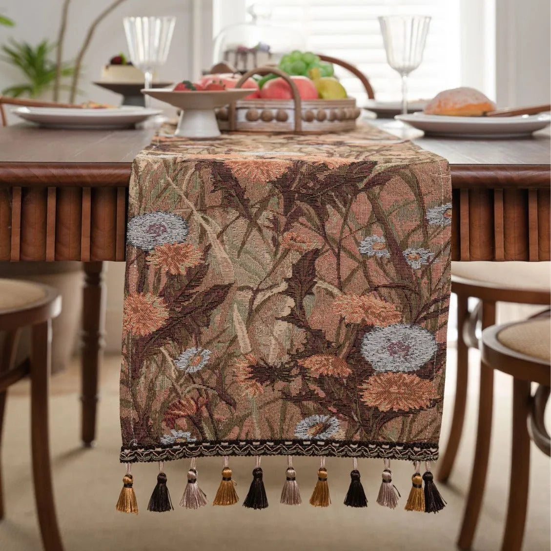 Beige jacquard table runner with long tassels and floral pattern laid on a wooden table