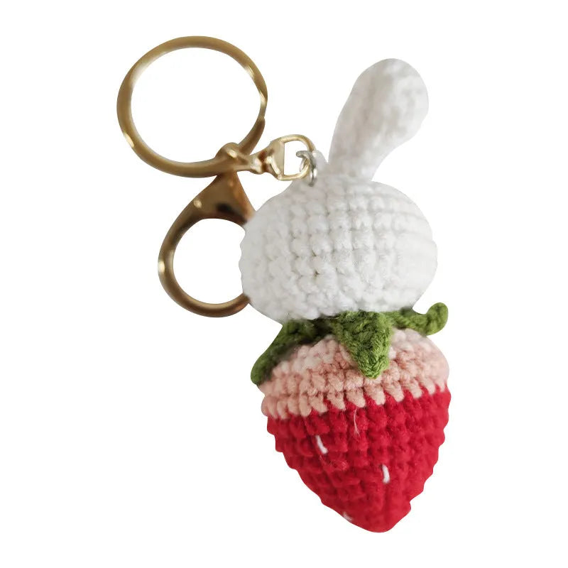 Hand-woven white wire pendant keyring with cartoon rabbit and strawberry design.