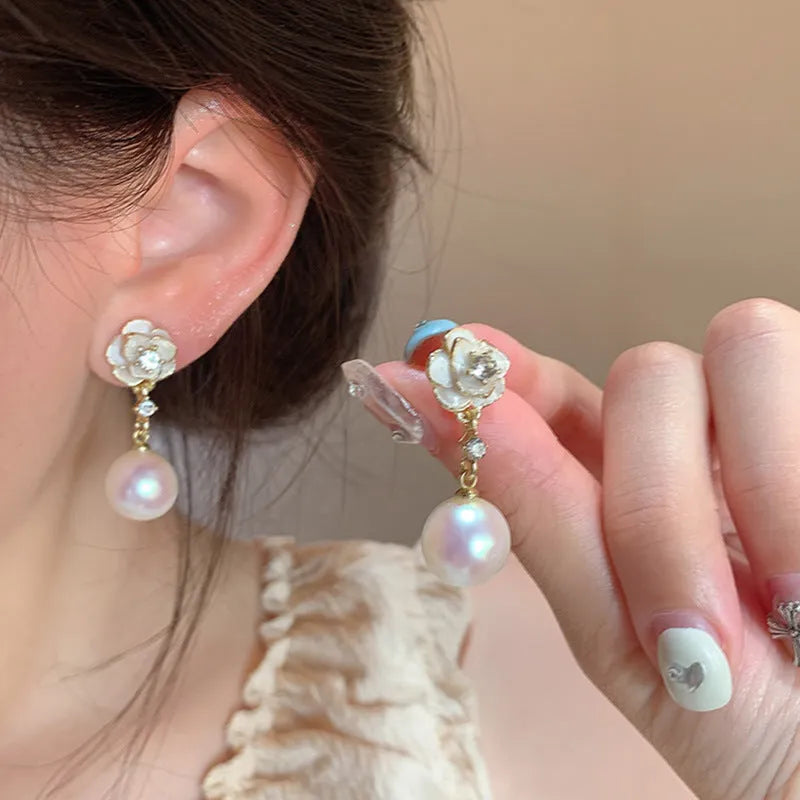 Close-up of a pair of camellia flower stud earrings for women in alloy metal.
