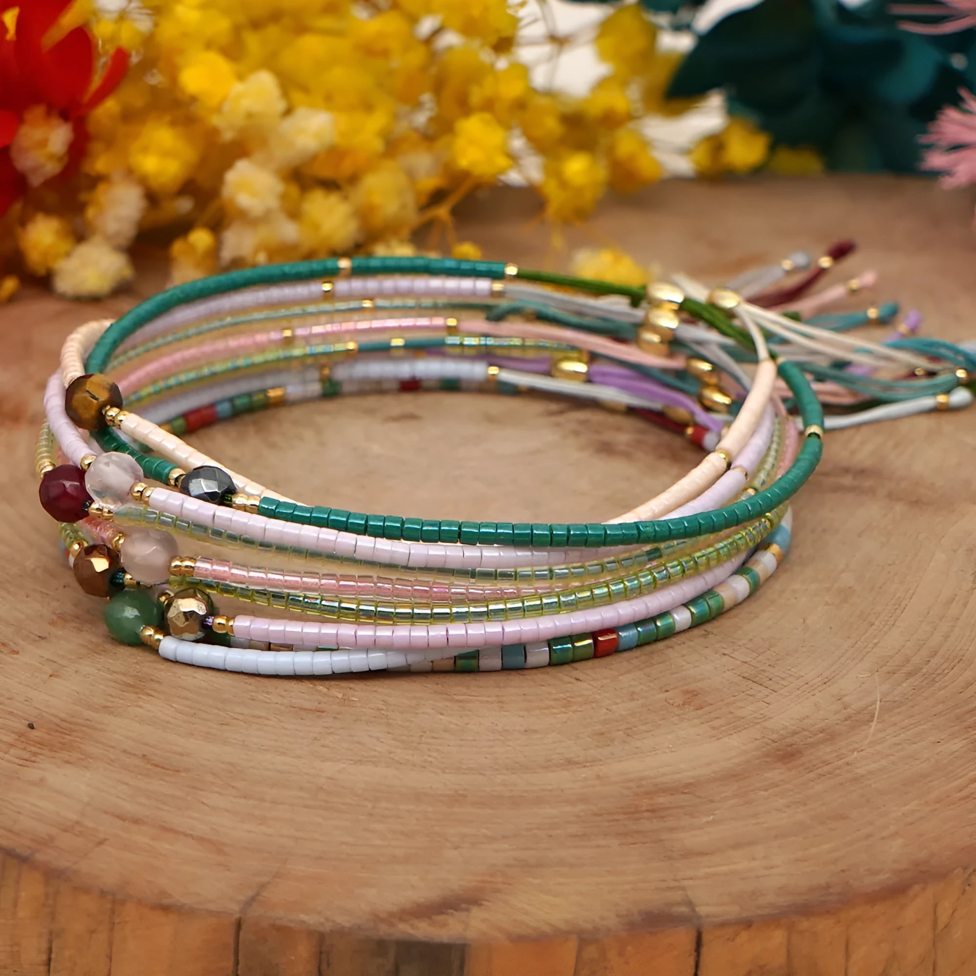 Handmade bohemian bracelet with colourful glass and glaze geometric beads on a wrist.