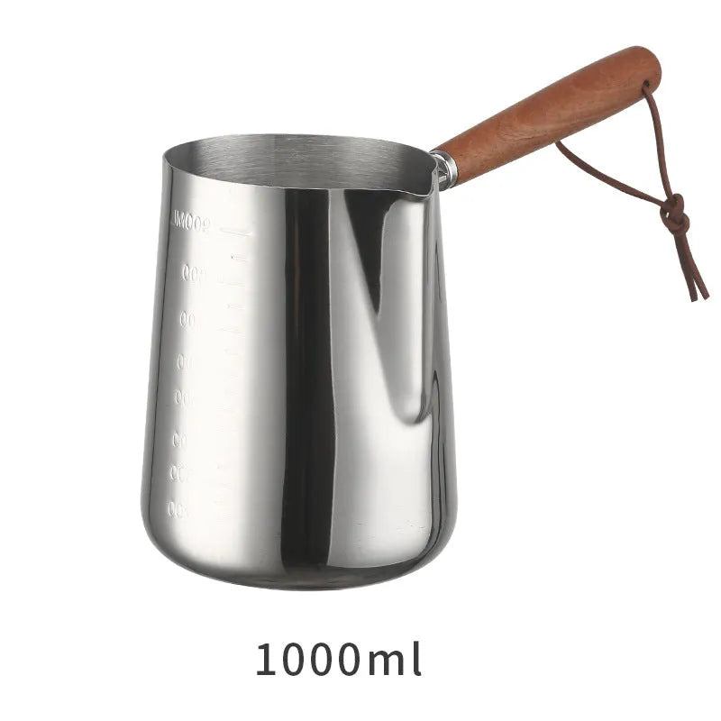 Stainless steel milk pouring cup with wooden handle and interior volume measurement scale.