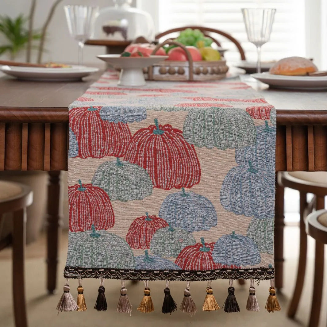 Beige jacquard table runner with long tassels and floral pattern laid on a wooden table