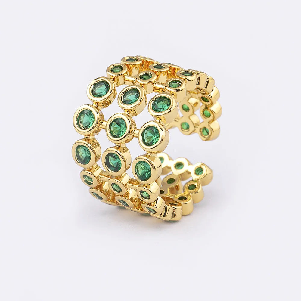 Gold plated ring with three-layer design and green zircon stones on a wide band.