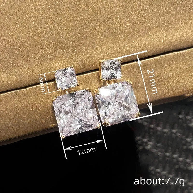 A pair of geometric square earrings in gold and white gold plating options, shown from the front.