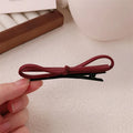 Wine red leather bow barrettes hair clips showing handcrafted bow design