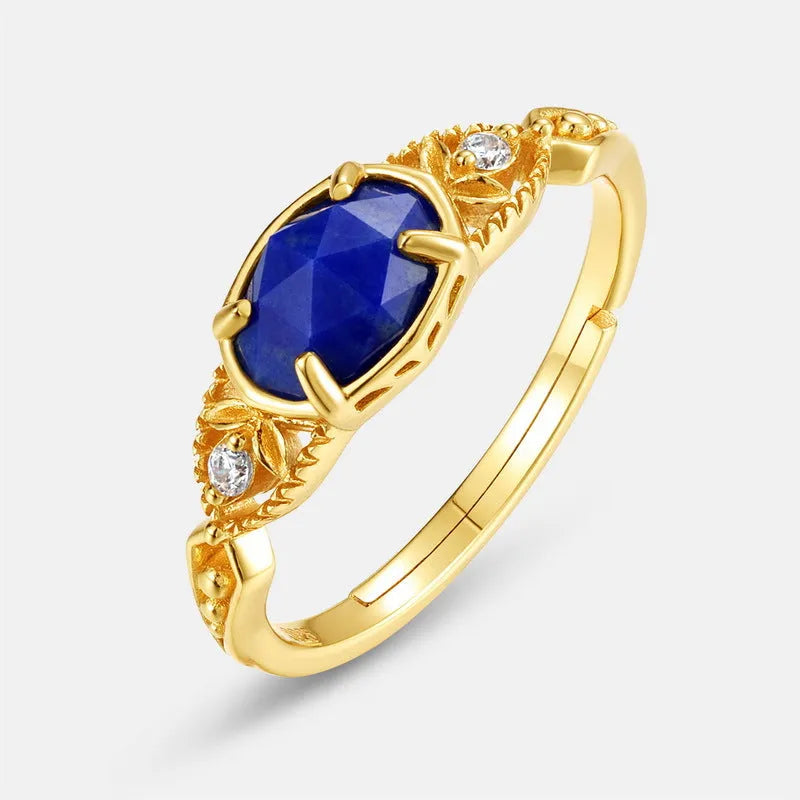 Silver geometric ring with an oval blue lapis lazuli stone on a model's finger.