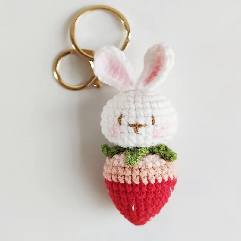 Hand-woven white wire pendant keyring with cartoon rabbit and strawberry design.