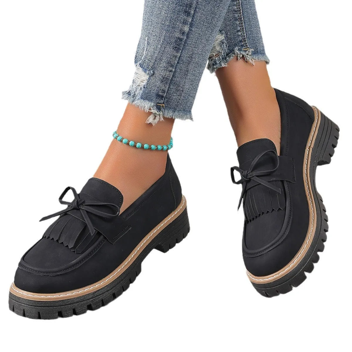 Plus size women's black loafers with a decorative bowknot and tassel on a chunky rubber sole.