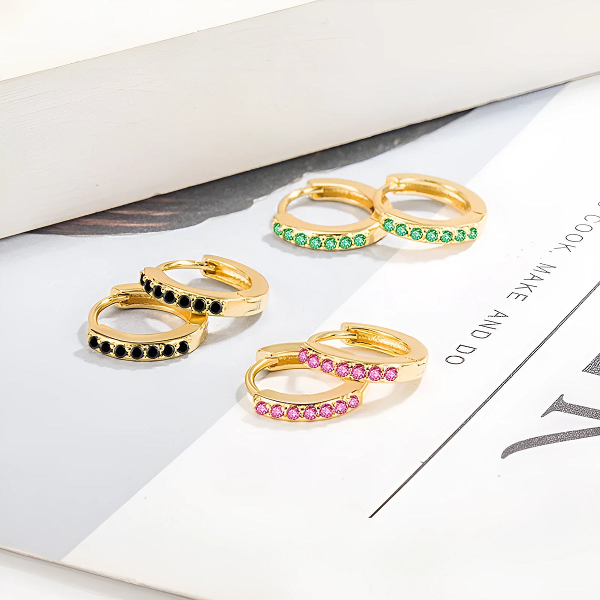 Gold-tone copper geometric hoop earrings with inlaid zircon in black, red, or green, one pair