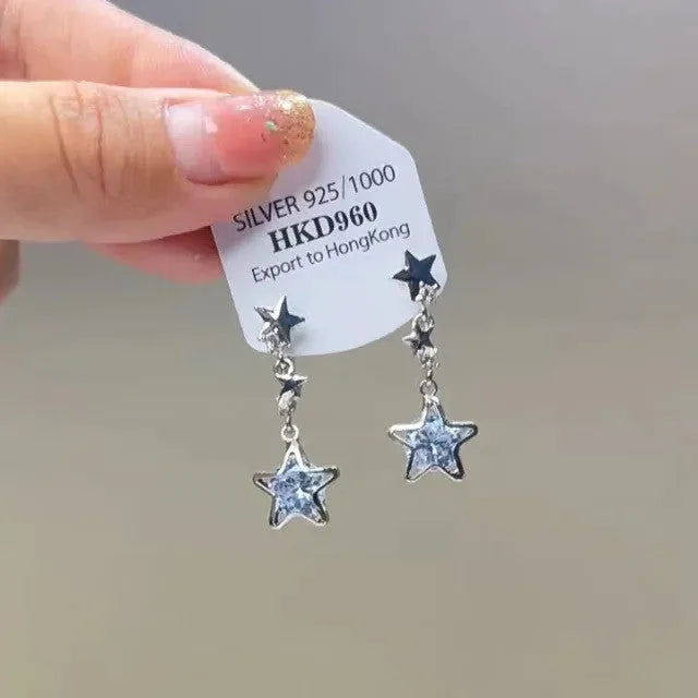 Geometric alloy ear clips with heart shape, rhinestone stars, and tassel details on a white background.