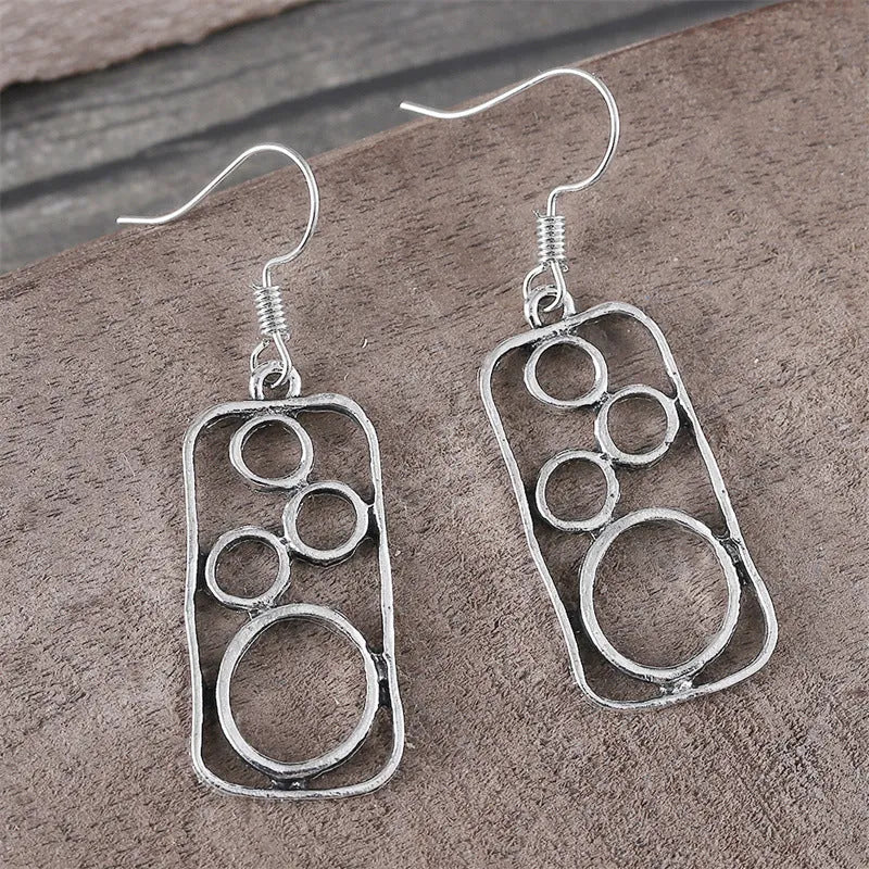 A pair of geometric round earrings with an irregular square shape in antique silver finish.