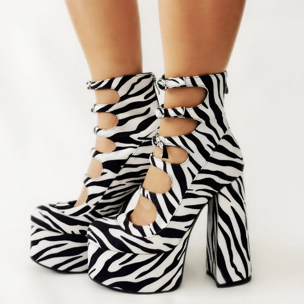 Women's black patent leather platform high heels with a thick serpentine ankle strap and buckle fastening.