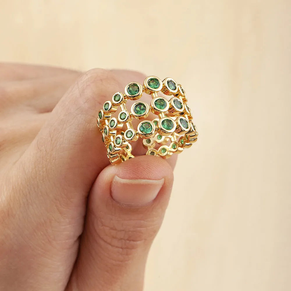 Gold plated ring with three-layer design and green zircon stones on a wide band.