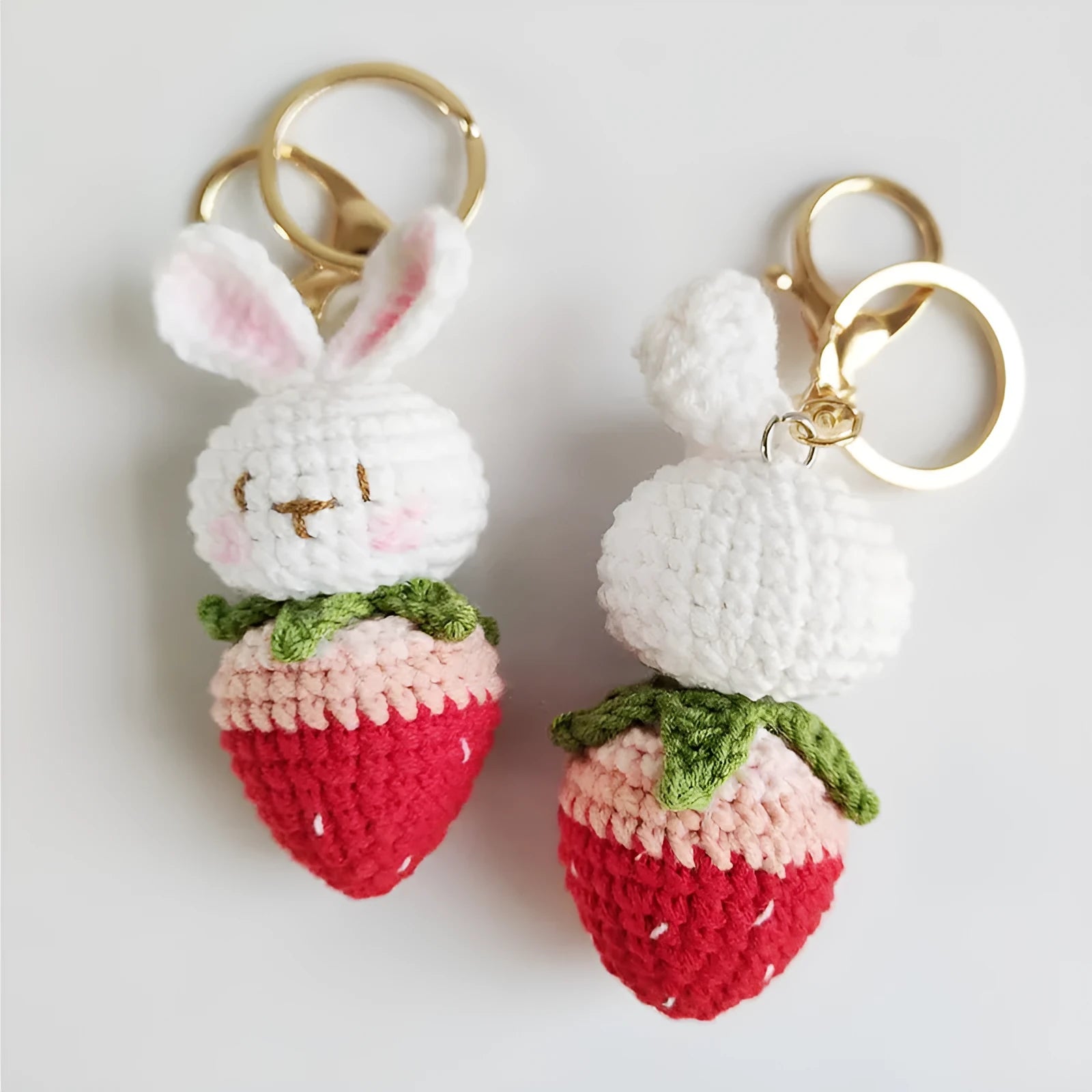 Hand-woven white wire pendant keyring with cartoon rabbit and strawberry design.