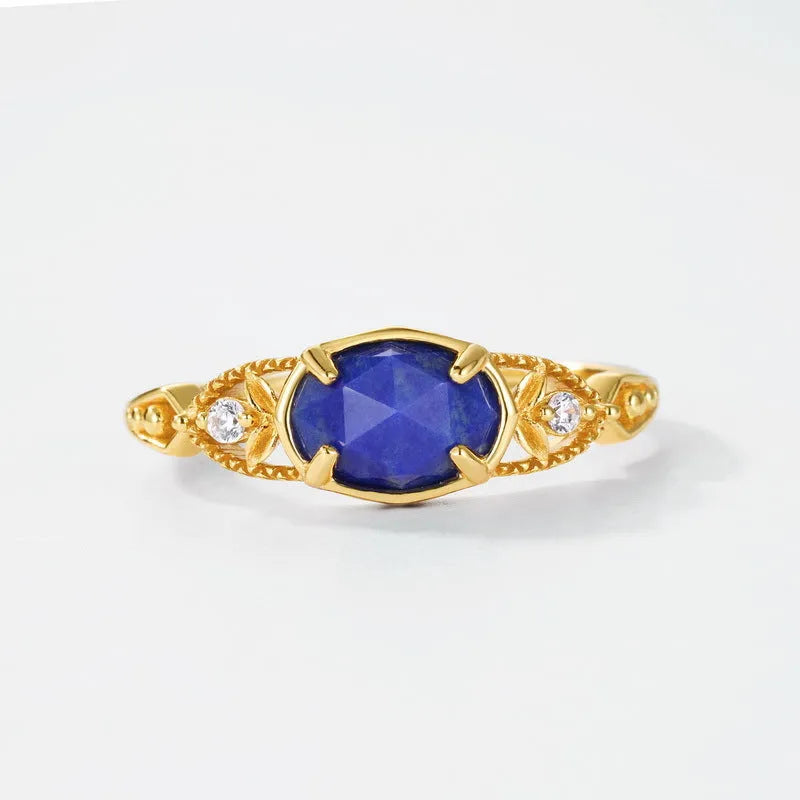 Silver geometric ring with an oval blue lapis lazuli stone on a model's finger.