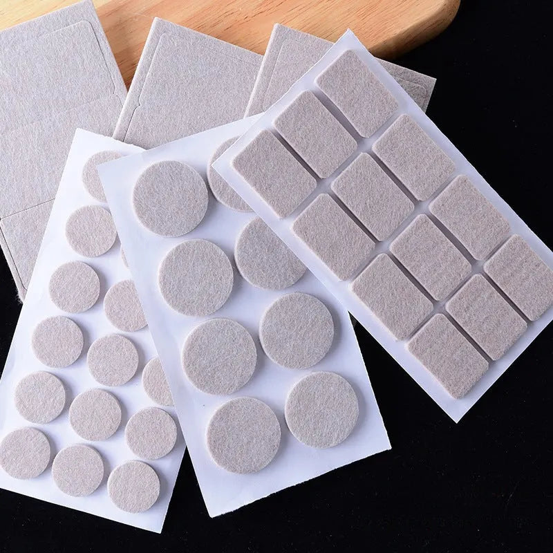 Beige plastic furniture leg stopper pads in five different sizes on a wooden floor
