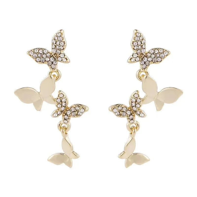 A pair of gold-coloured copper earrings with four detailed butterfly designs in a drop style.