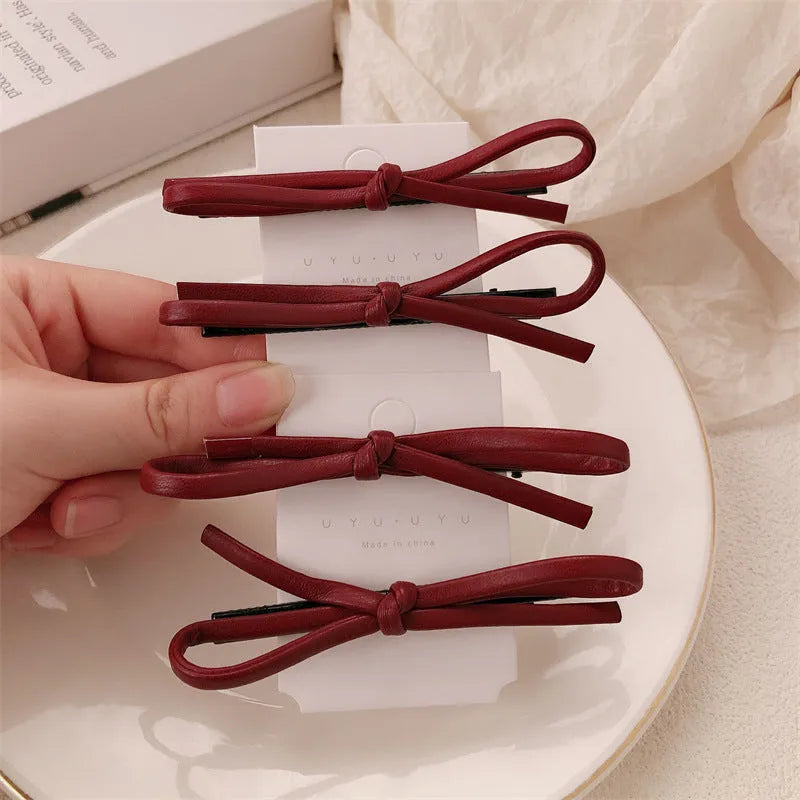 Wine red leather bow barrettes hair clips showing handcrafted bow design