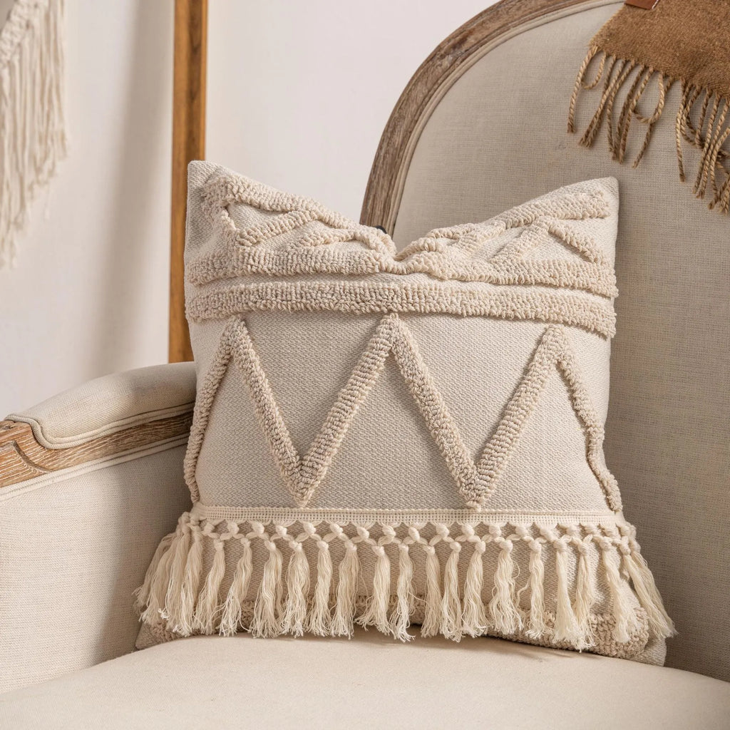 Knitted cushion cover with tassel fringe in a striped pattern, shown in spiral dots design.