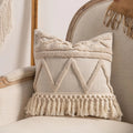 Knitted cushion cover with tassel fringe in a striped pattern, shown in spiral dots design.