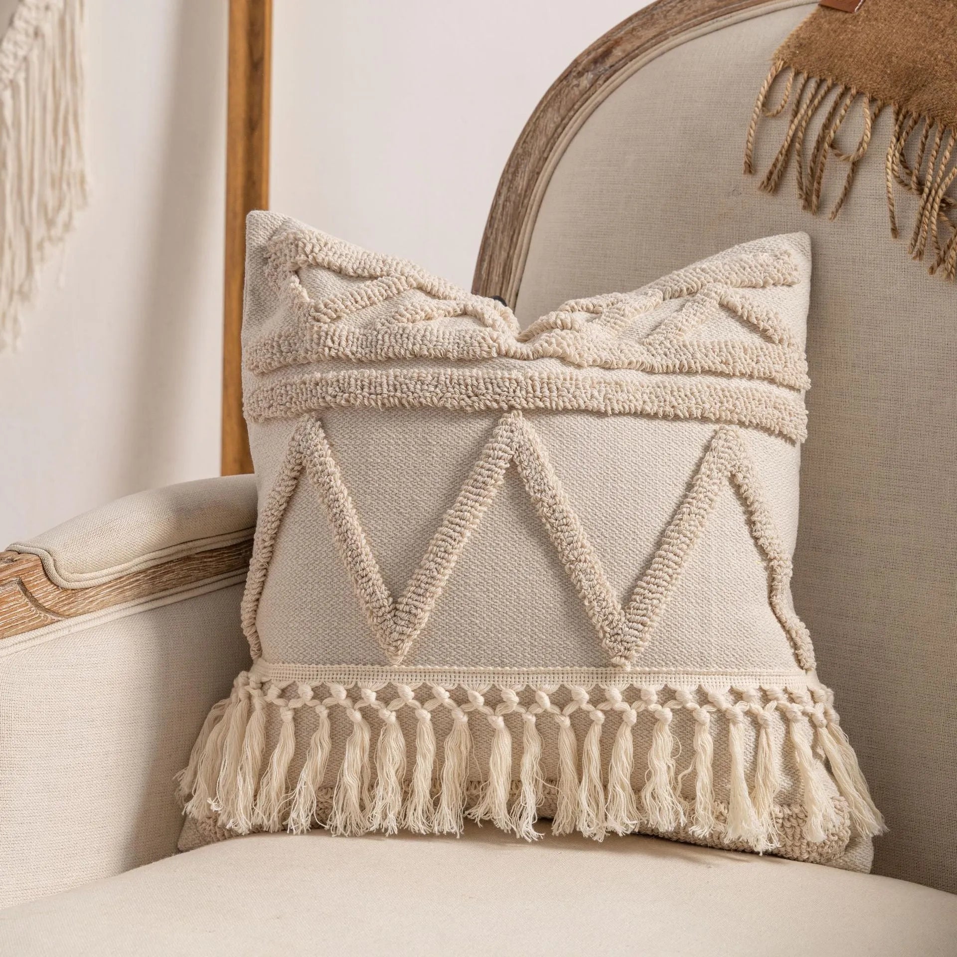 Knitted cushion cover with tassel fringe in a striped pattern, shown in spiral dots design.