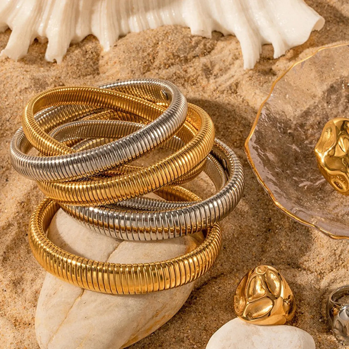 Women's gold titanium steel elastic bracelet with vertical stripe ring pattern, shown at an angle.