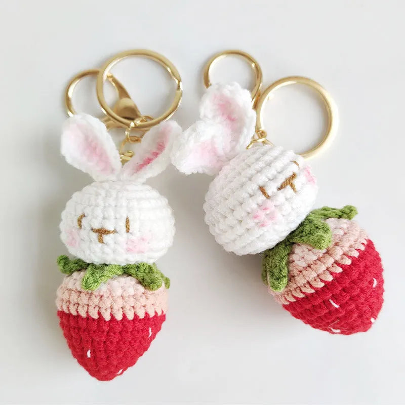 Hand-woven white wire pendant keyring with cartoon rabbit and strawberry design.