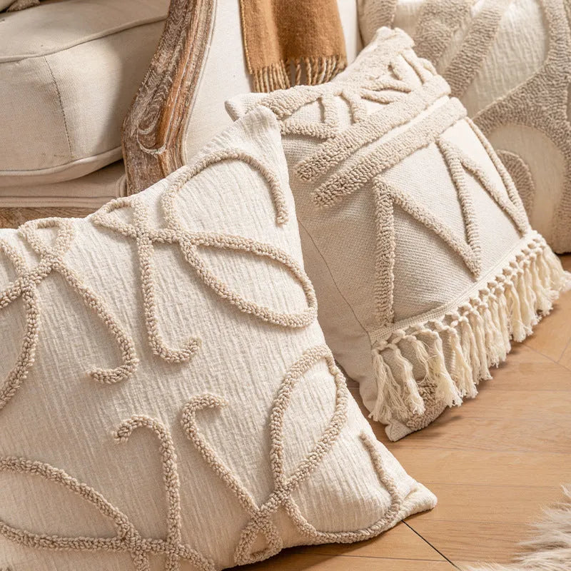 Knitted cushion cover with tassel fringe in a striped pattern, shown in spiral dots design.