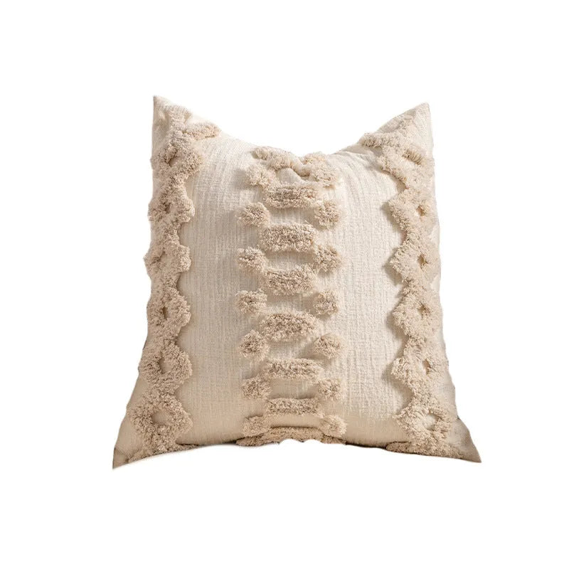 Knitted cushion cover with tassel fringe in a striped pattern, shown in spiral dots design.