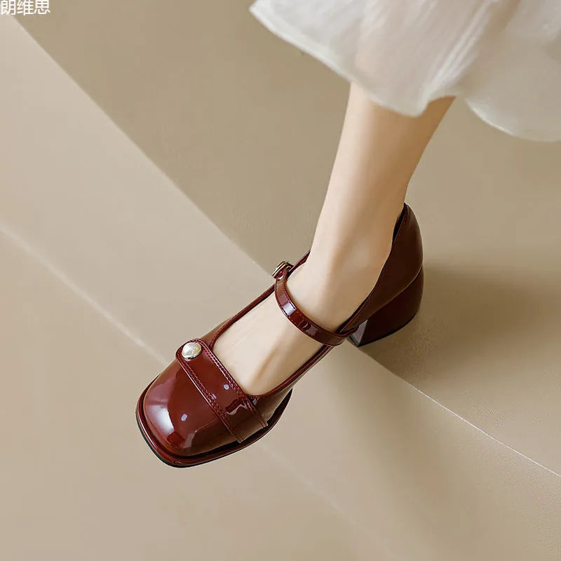 Women's apricot patent leather chunky heel pumps with a buckle fastening and square toe.
