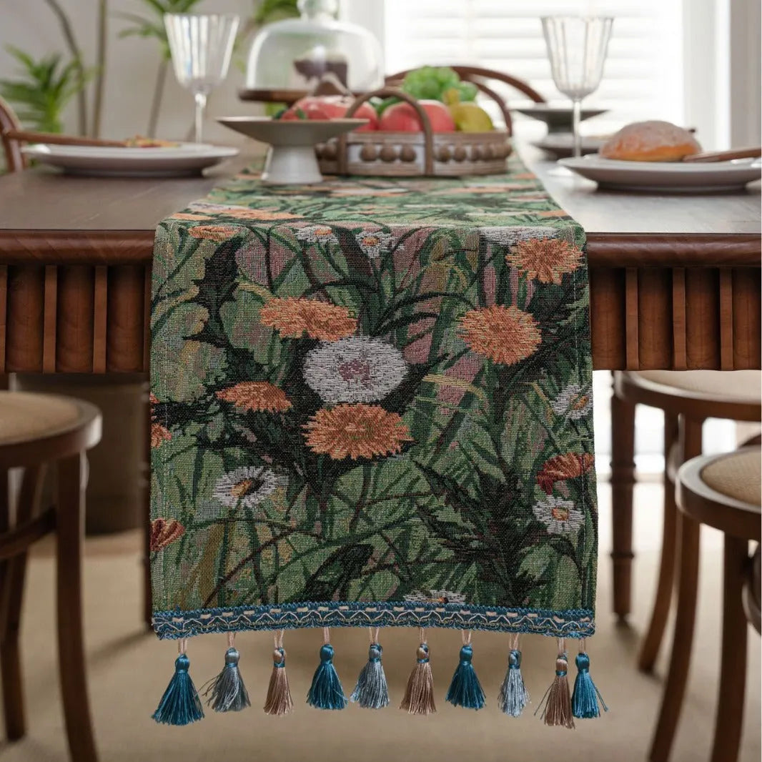 Beige jacquard table runner with long tassels and floral pattern laid on a wooden table