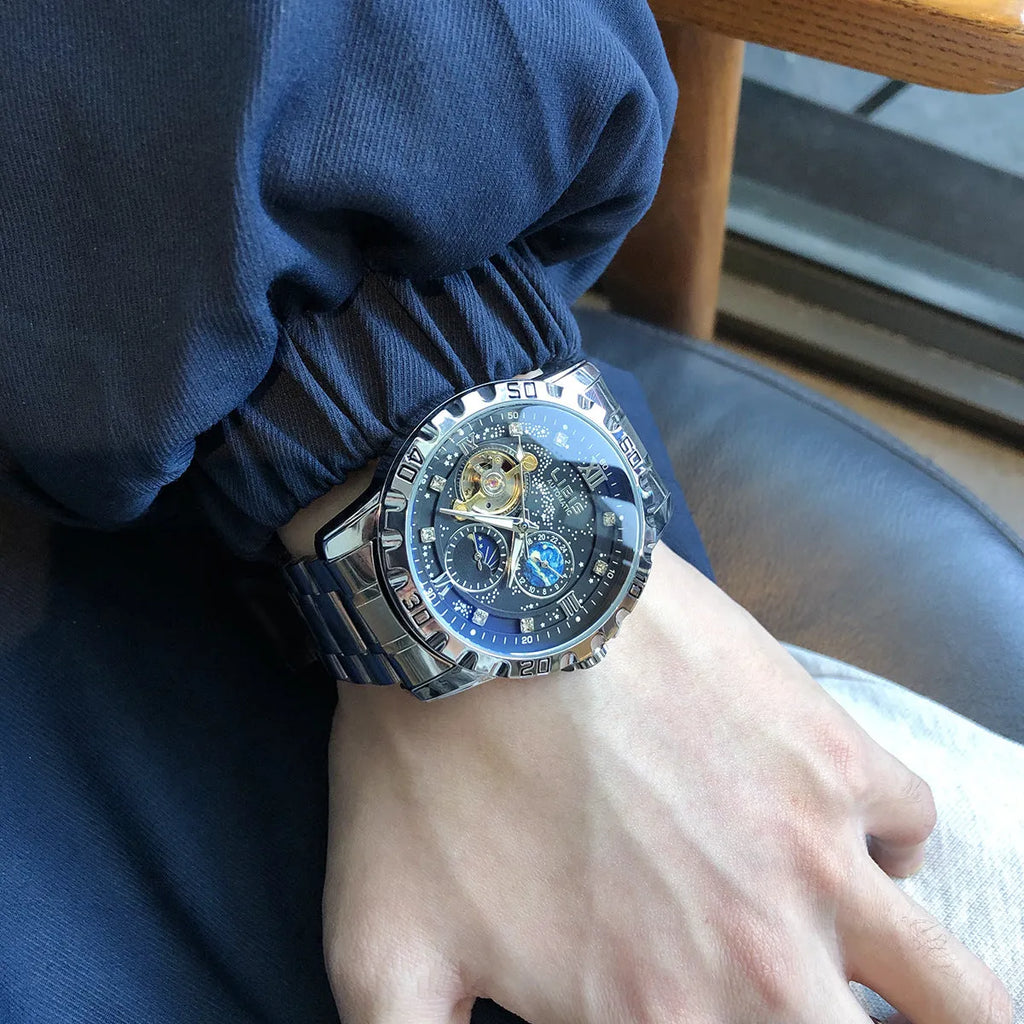 Men's silver automatic watch with black starry dial, luminous hands, and brown leather strap
