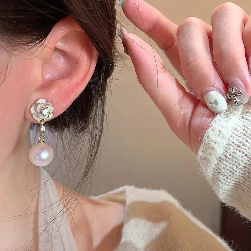 Close-up of a pair of camellia flower stud earrings for women in alloy metal.