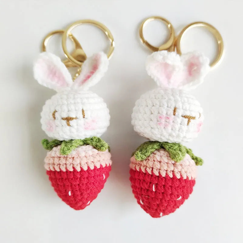 Hand-woven white wire pendant keyring with cartoon rabbit and strawberry design.