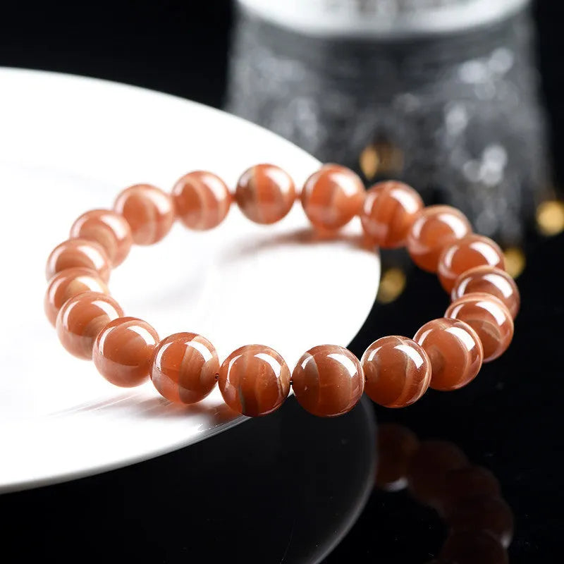 Natural Old Mine Rhodochrosite round bead bracelet from Peru showing pinkish-red mineral colour