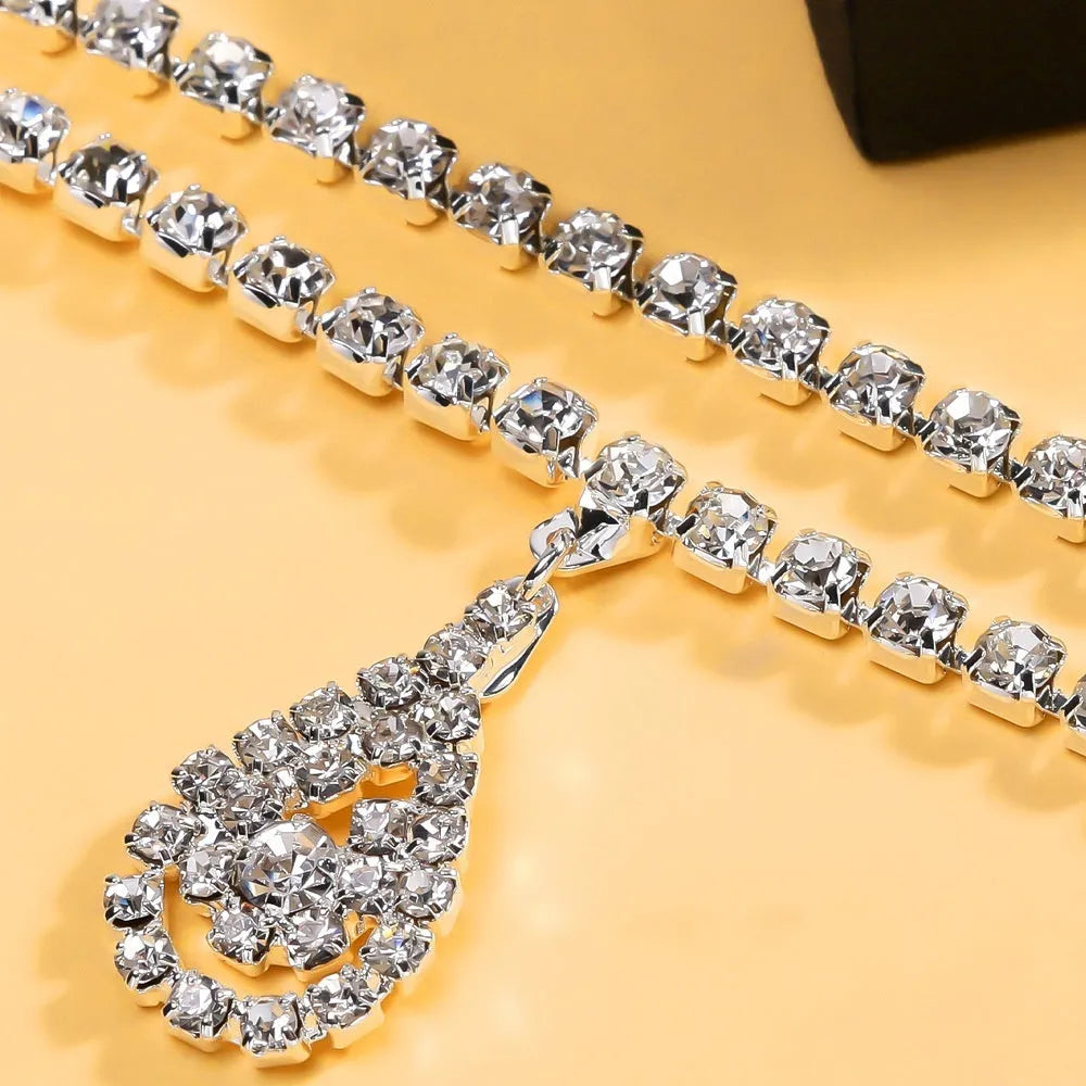 Gold or silver rhinestone waist chain with water drop pendant and tassel elements, showing lobster clasp closure