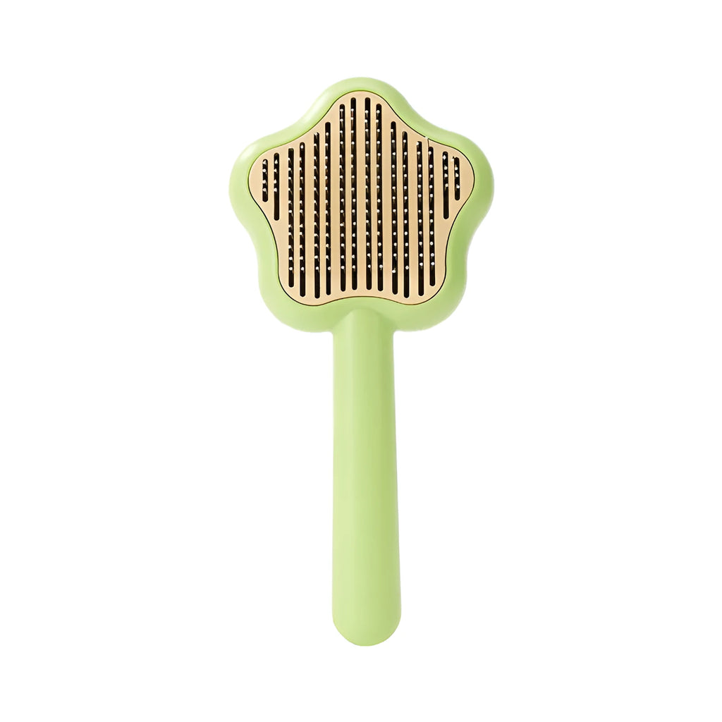 Green stainless steel cat comb with magic wand self-cleaning mechanism showing needle teeth and plastic handle