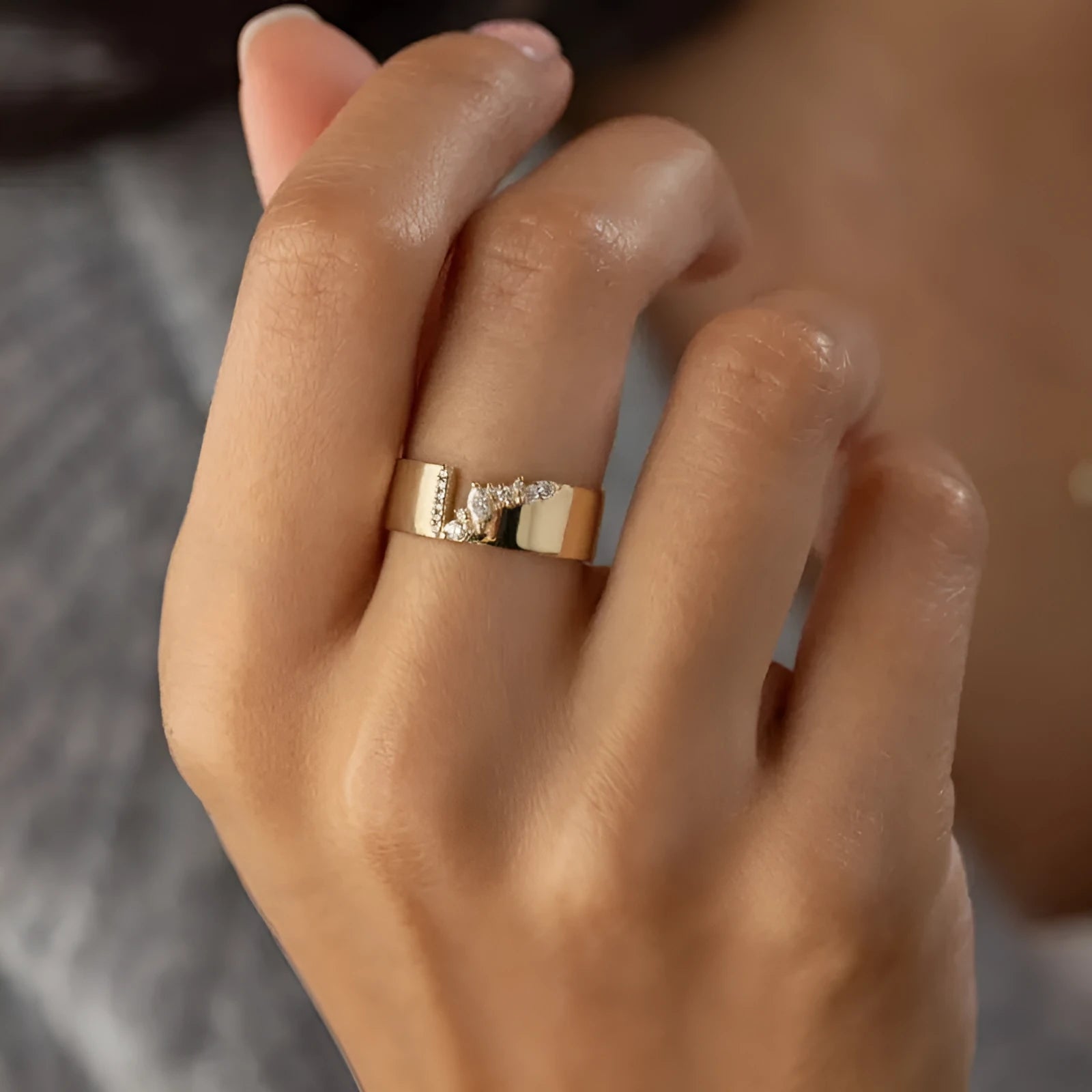 Gold electroplated zircon ring on finger, showing metallic finish and decorative elements