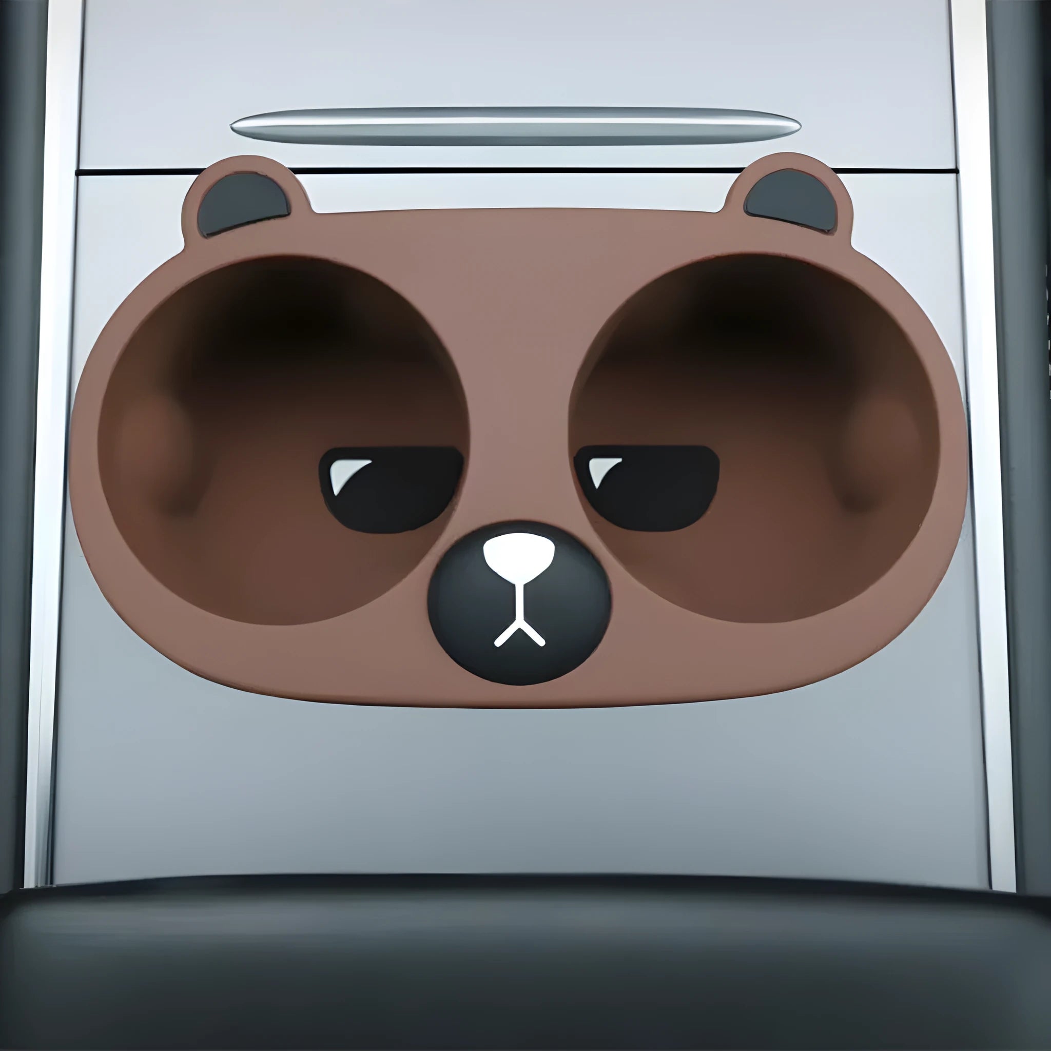 A grey silicone insert designed to fit into a car's central console cup holder to stabilise drinks.