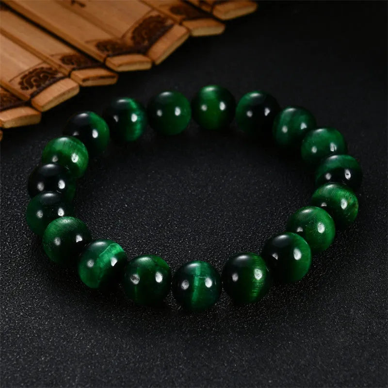 Natural green tiger eye stone bracelet with geometric polished beads on a wrist.