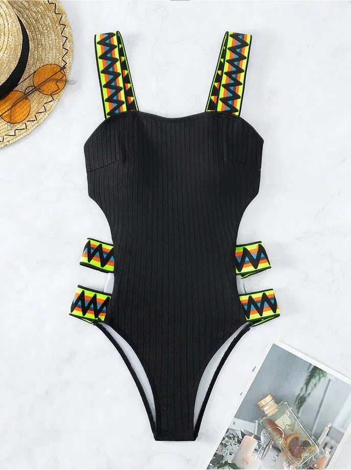 Solid colour women's one-piece swimsuit on a hanger, available in black and orange.