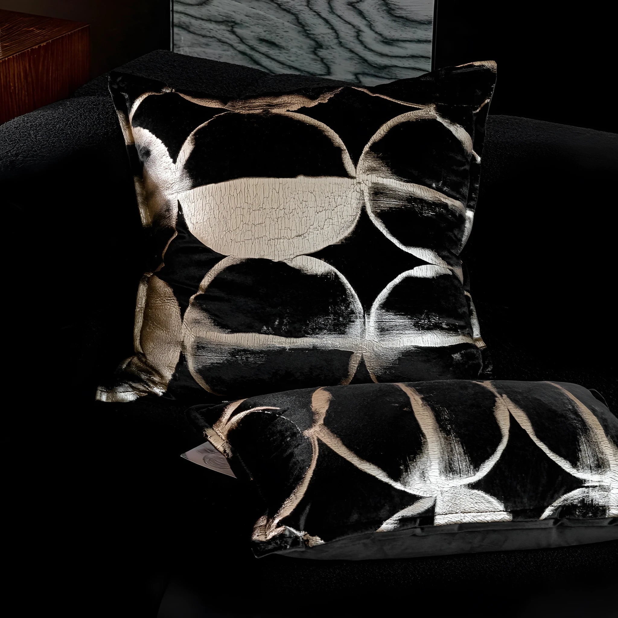 Black gold abstract pattern decorative cushion with removable cover in three size options on a sofa.