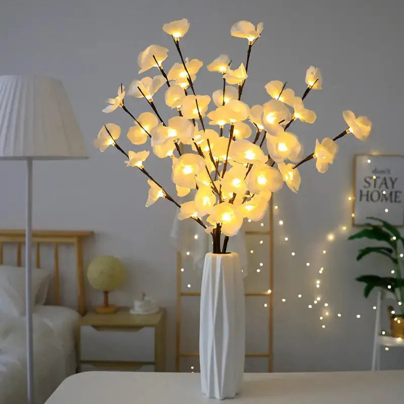 Pink LED phalaenopsis orchid branch decorative light on a table, 65cm long with warm white lights.