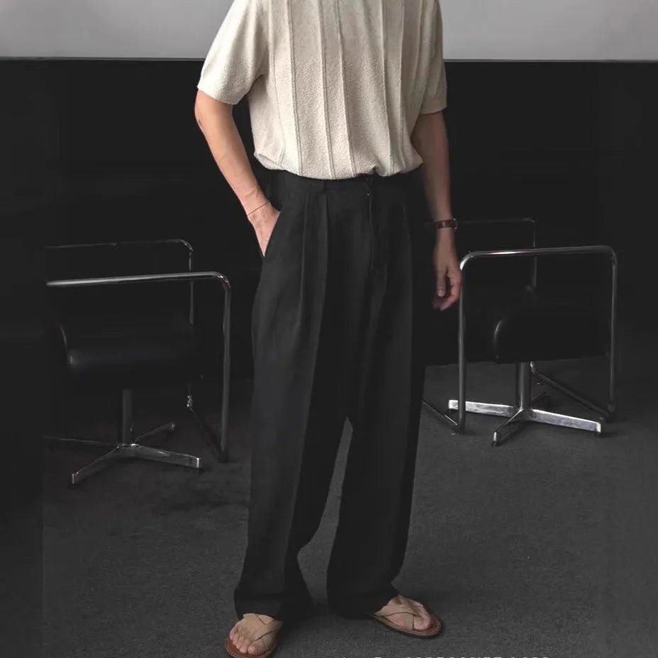 Men's apricot coloured loose-fit cotton linen trousers with a pencil leg on a plain background