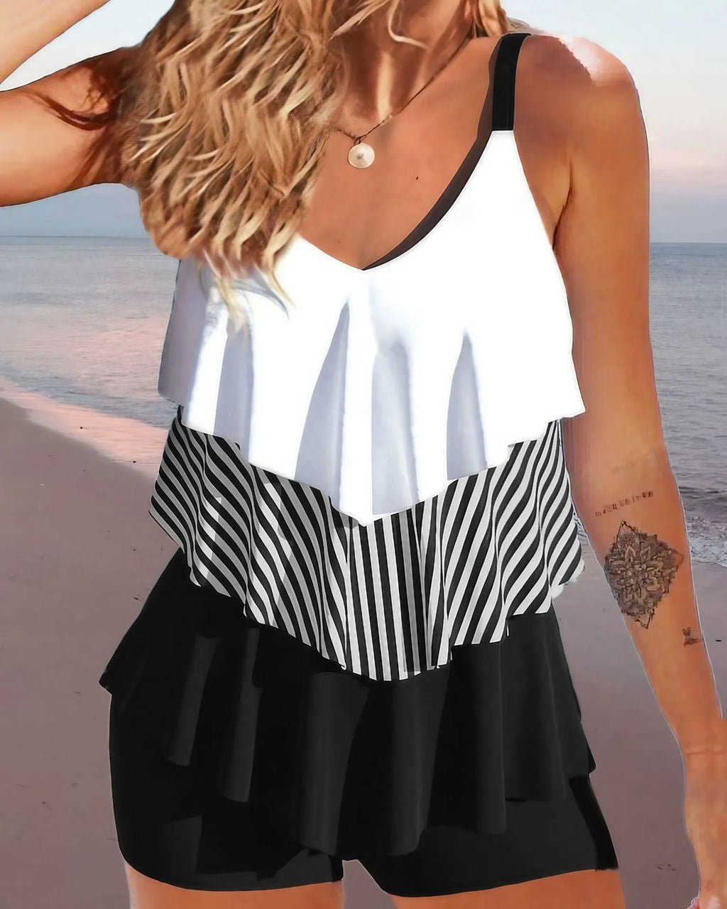 Women's sleeveless backless bikini swimsuit with ruffle detail and brief shorts.