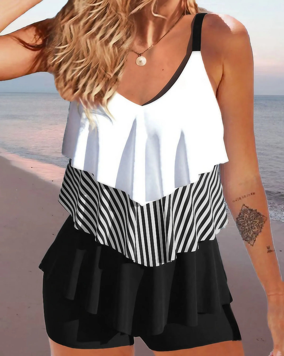Women's sleeveless backless bikini swimsuit with ruffle detail and brief shorts.
