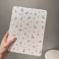 Transparent floral tri-fold iPad protective case with built-in stand, shown closed with magnetic clasp.